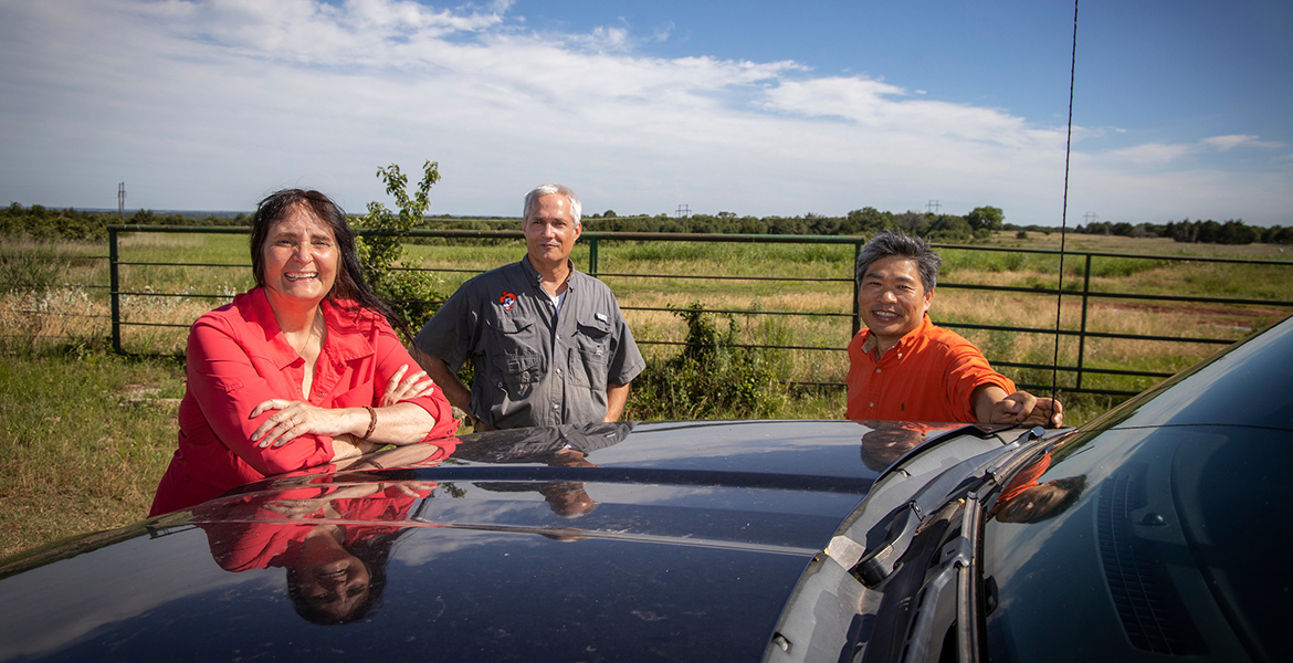 Photo of Gail Wilson, Rodney Will and Chris Zhou out among the grasslands.