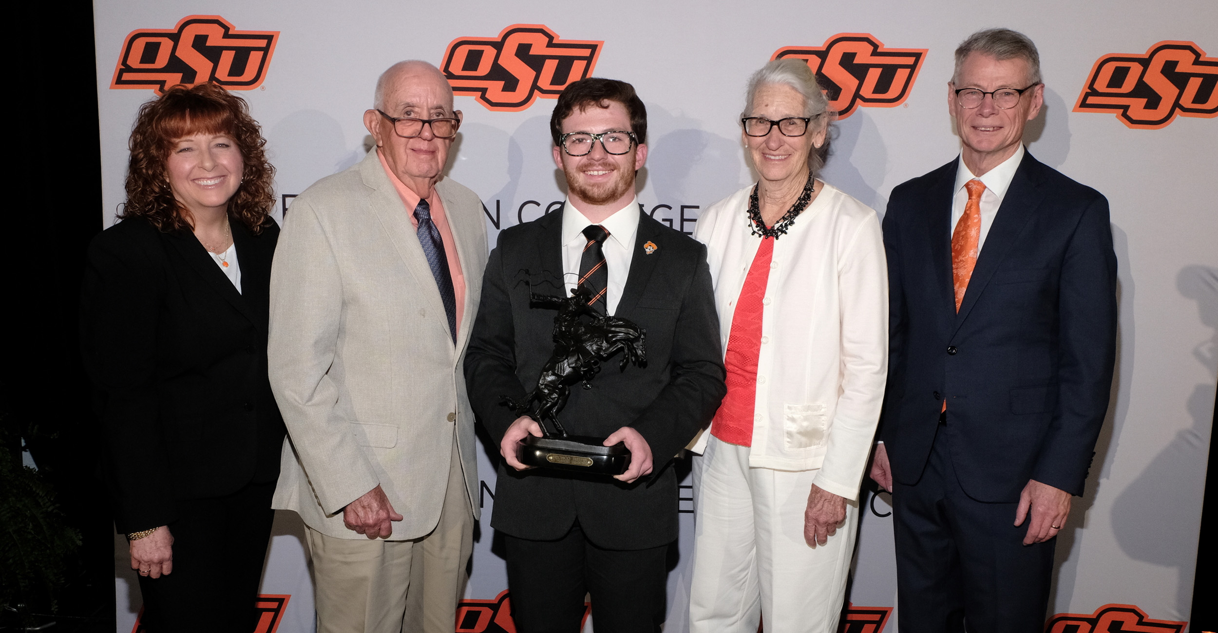 Cynda Clary, Louis Gardner, Rio Bonham, Betty Gardner and Tom Coon pose for a photo at the 2023 Ferguson College of Agriculture Scholarship and Awards Banquet. Rio is holding a large statue that he was awarded.