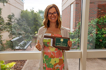 4-H volunteer Rachel Gronwald holding the 2026 State 4-H Volunteer of the Year Award and 2026 Southeast District 4-H Volunteer of the Year Award.