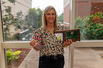 4-H volunteer Denise Tulloh holding the 2026 State 4-H Lifetime Volunteer Award and 2026 West District 4-H Lifetime Volunteer Award.