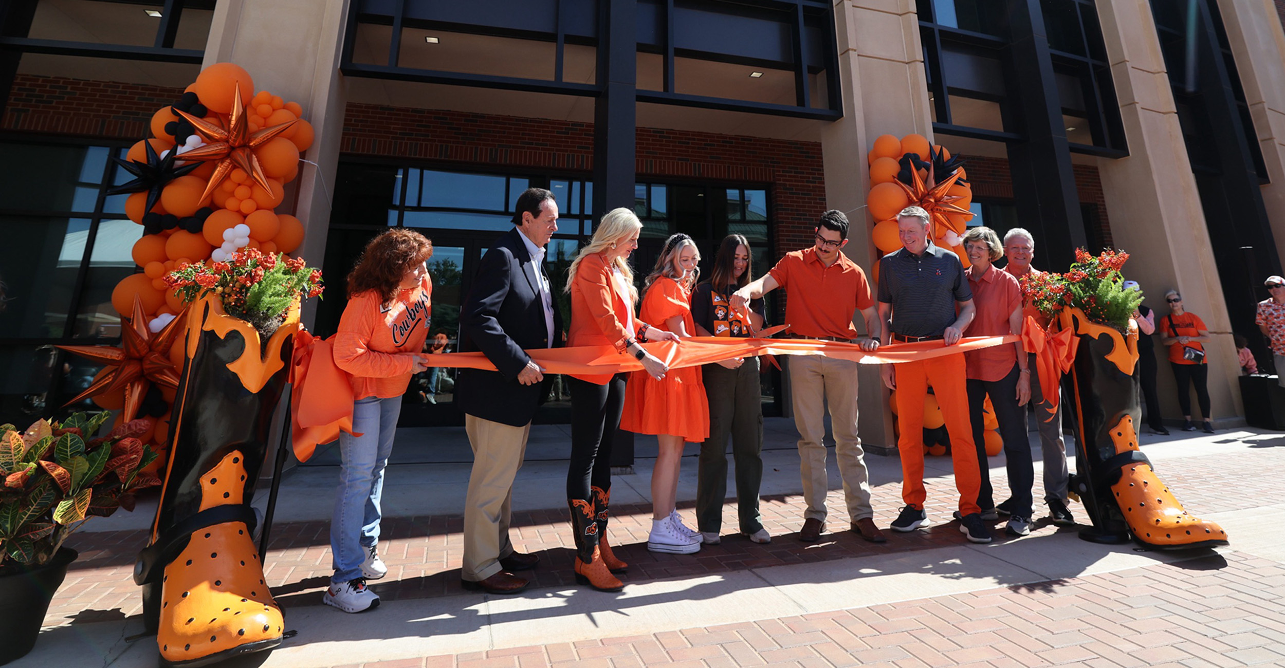 University officials and students cut ribbon in front of Ag Hall