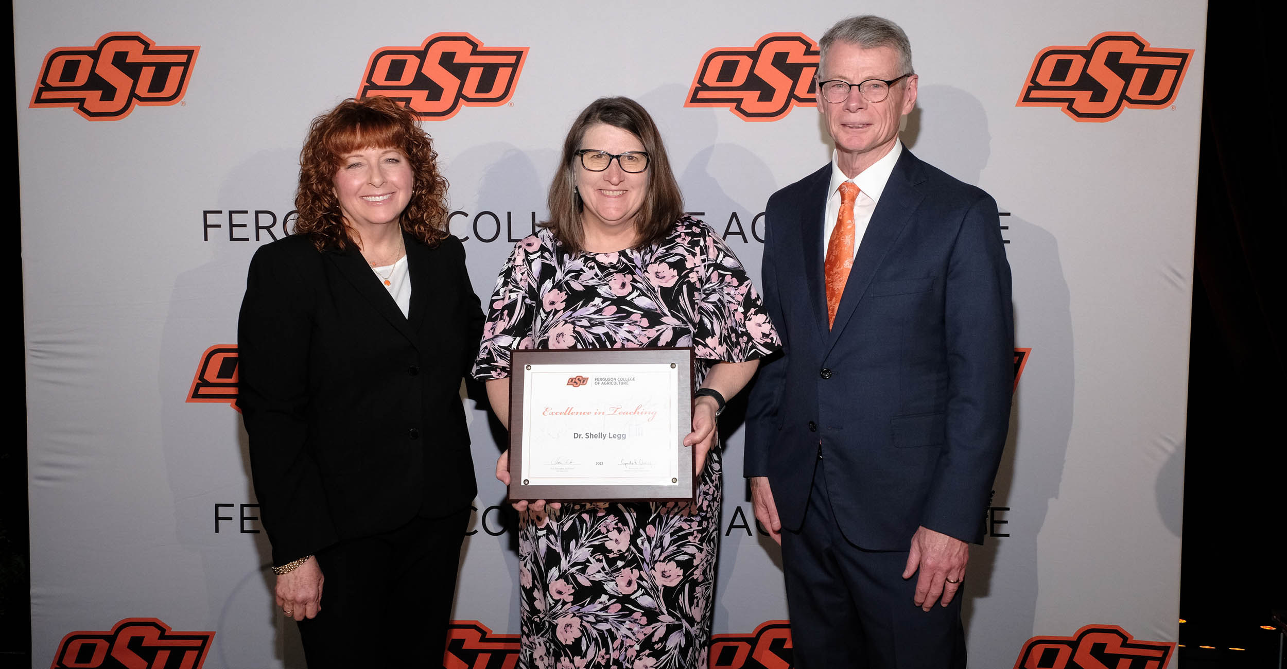 Standing left to right Cynda Clary, Shelly Legg and Thomas Coon. Legg is holding an award plaque.