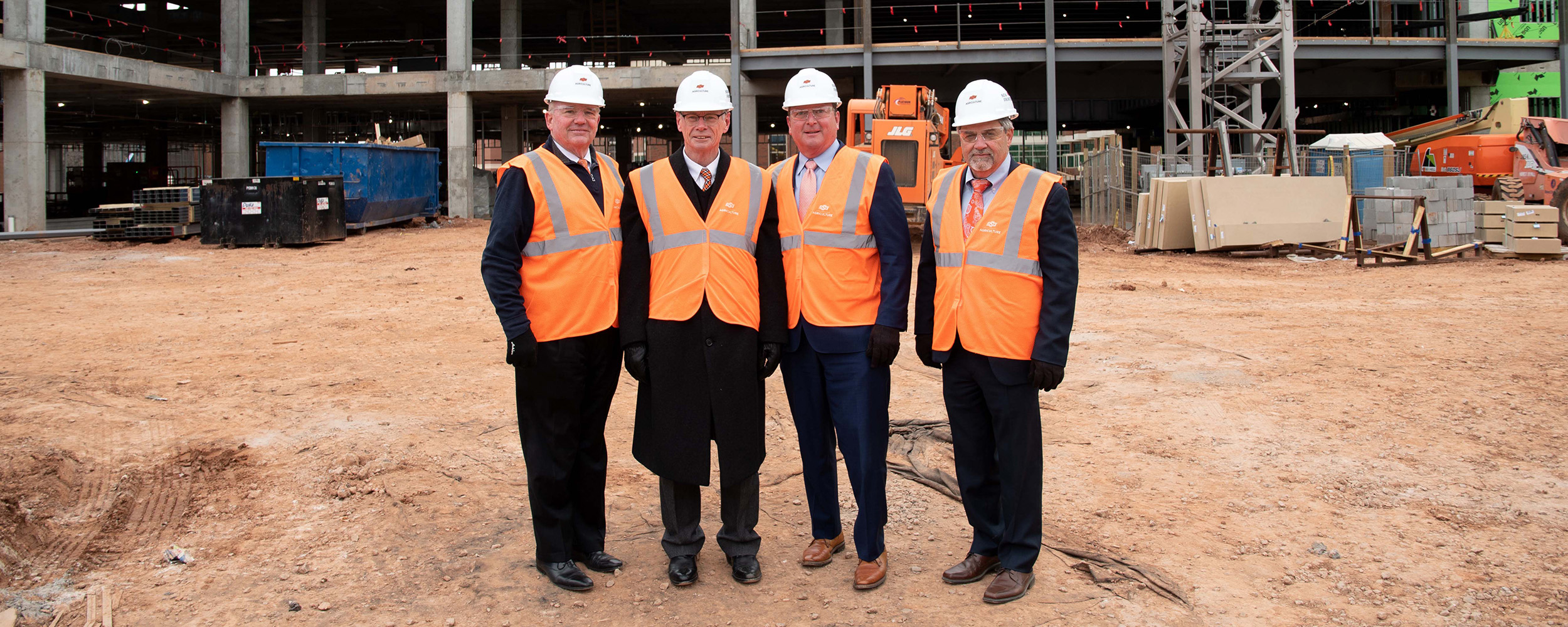 Regents stand in front of New Frontiers construction site