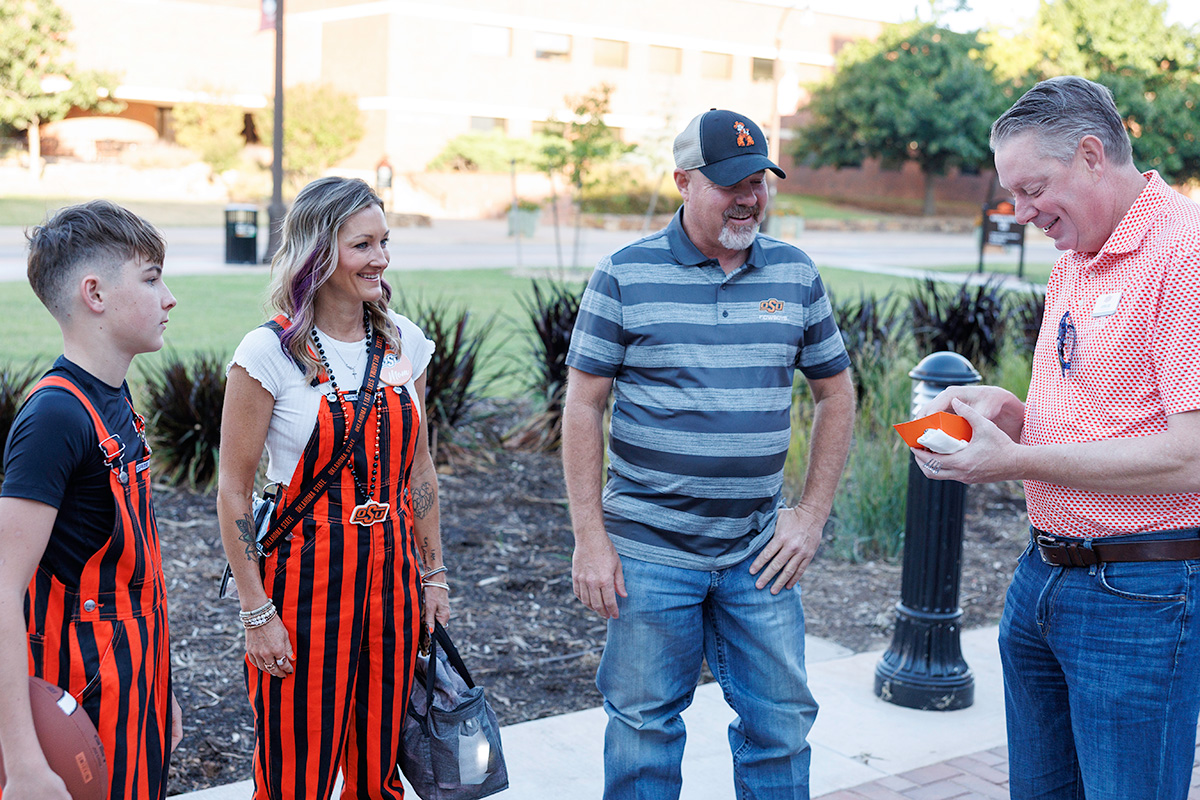 Jett Stewart, Lori Stewart and Jarrod Stewart from Keyes, Oklahoma, visit with Jayson Lusk, vice president and dean of OSU Agriculture, during the OSU Agriculture Tailgate.