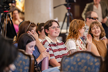 Audience members listen and raise their hands during a Humanities Week lecture in OSU’s Helmerich Browsing Room.