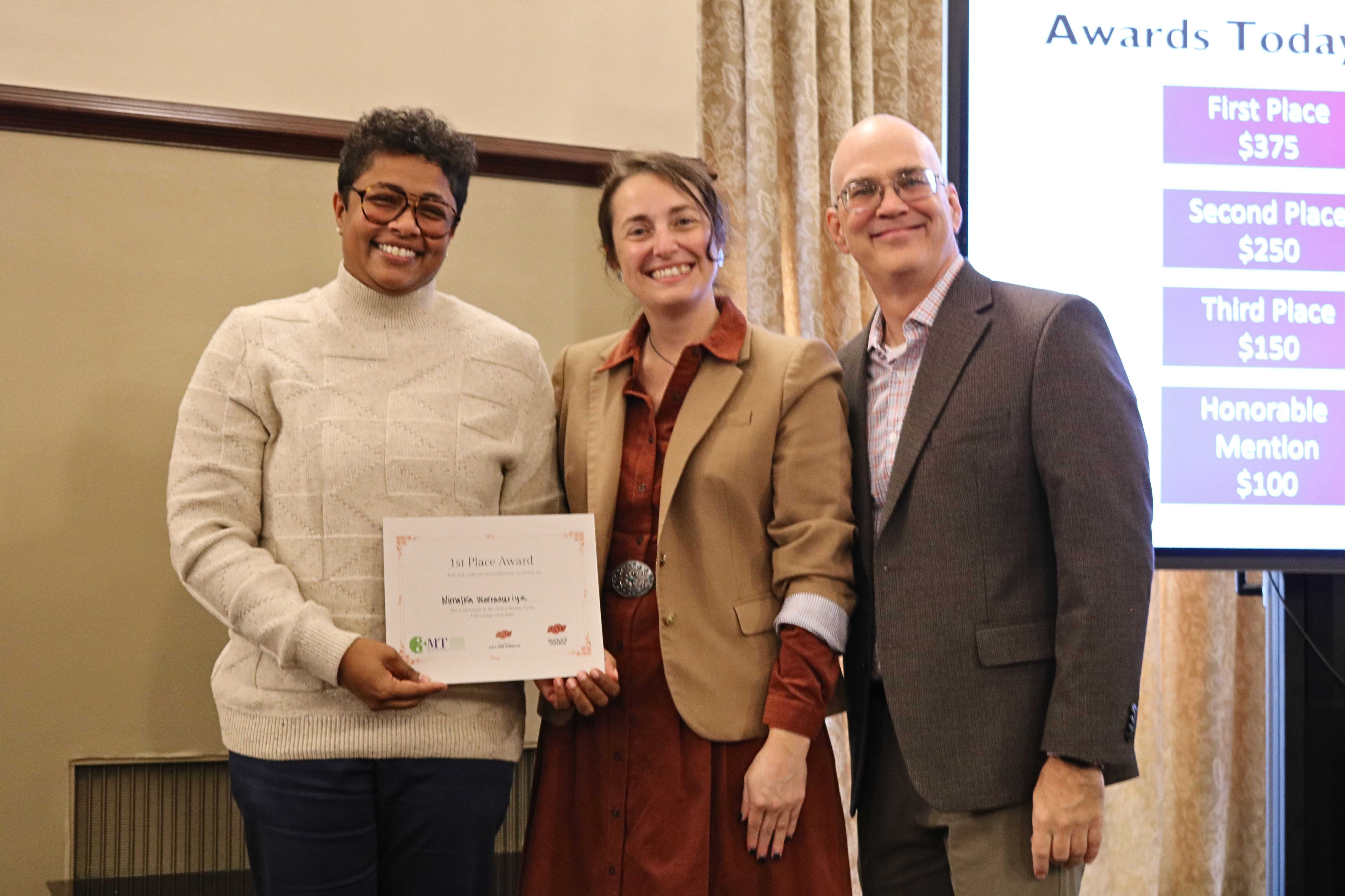 First place in the 2026 College of Arts and Sciences Three Minute Thesis competition, Nimalka Weerasuriya, with Dean Melinda Cro and Associate Dean for Research Jason Belden.