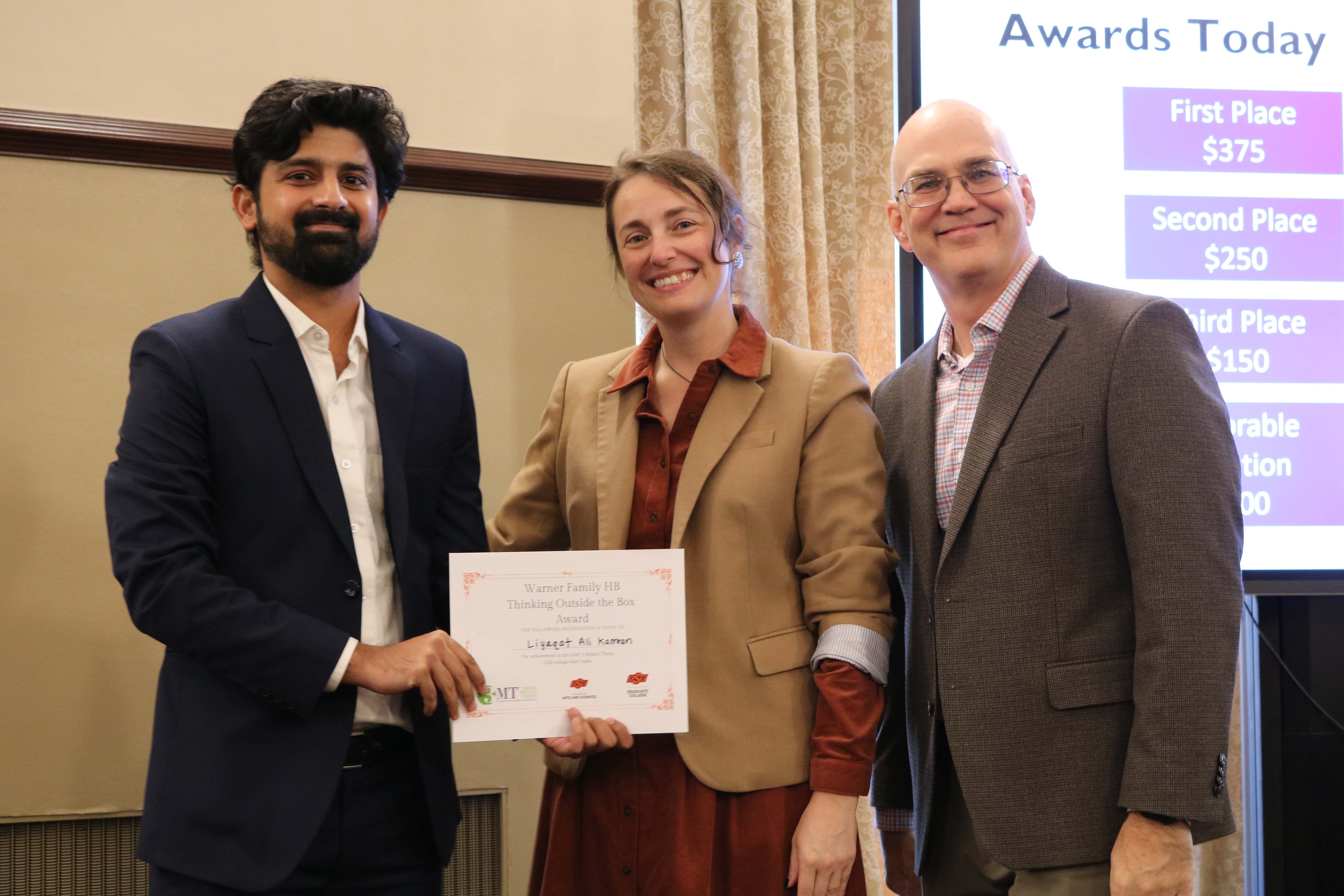 Thinking outside the box winner in the 2026 College of Arts and Sciences Three Minute Thesis competition, Liyaqat Ali Kamran, with Dean Melinda Cro and Associate Dean for Research Jason Belden.