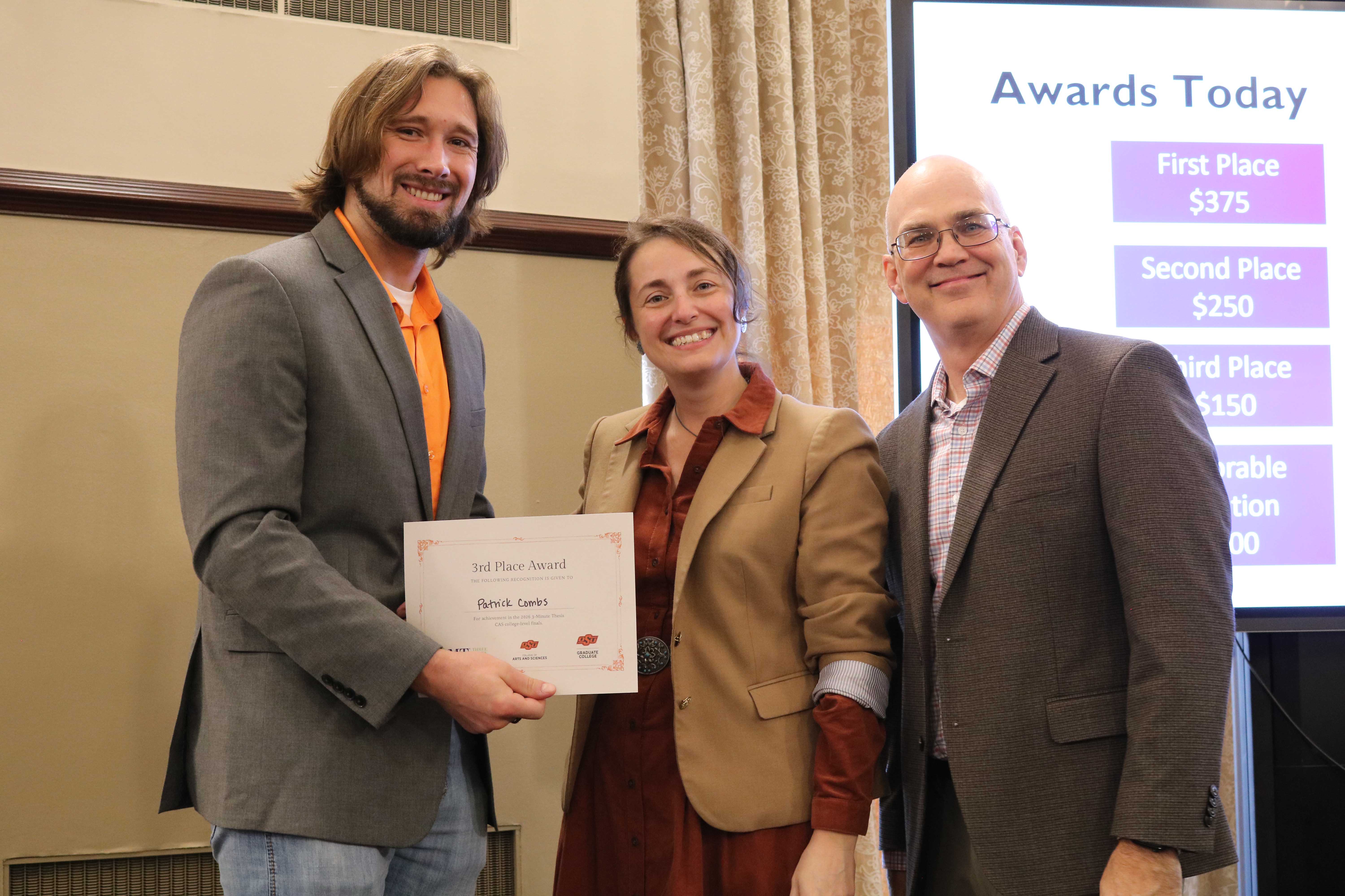 Third place in the 2026 College of Arts and Sciences Three Minute Thesis competition, Patrick Combs, with Dean Melinda Cro and Associate Dean for Research Jason Belden.