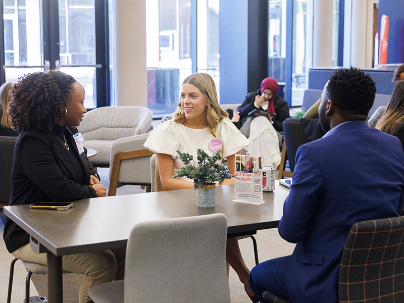 Three student entrepreneurs talk during a break at the Riata Business Plan Competition.