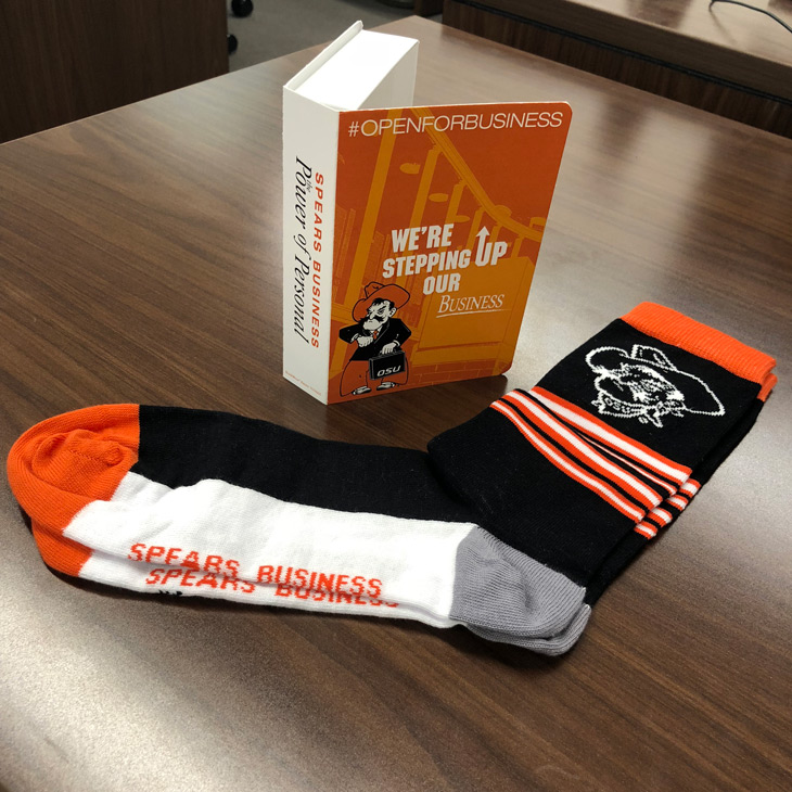 Pistol pete socks on desk with book.