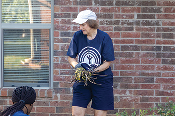 Dr. Julie Weathers cleans up a flower bed during the United Way Day of Caring in Stillwater