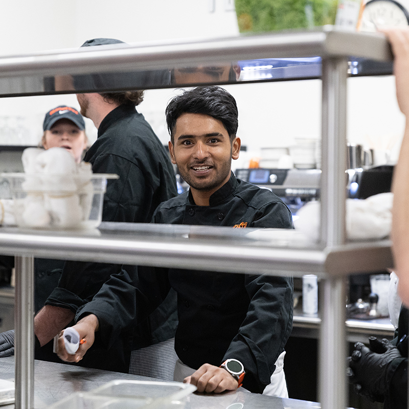 Ayush Bhattarai works in the kitchen during a chef series event.