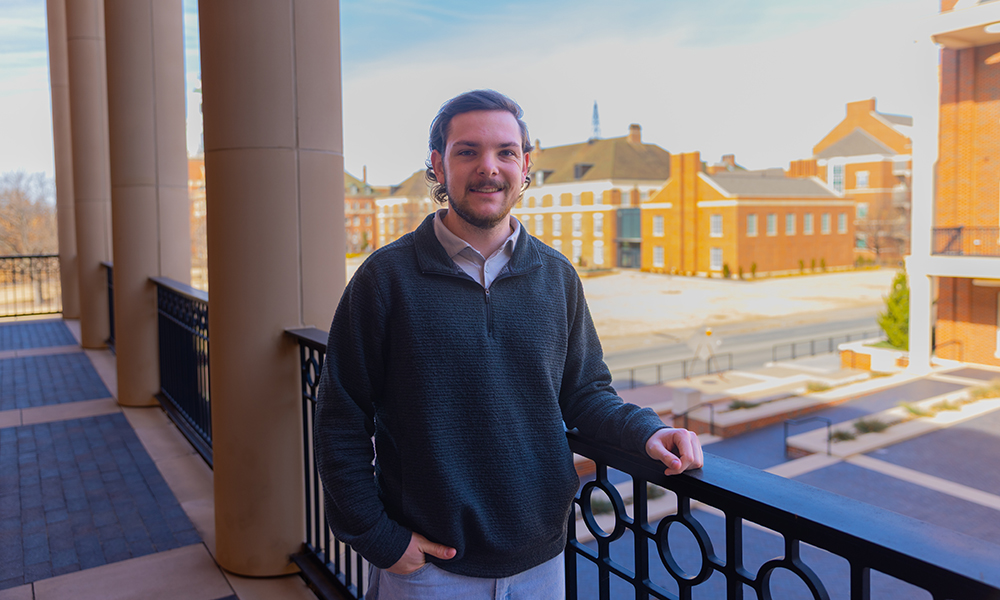 Kyler Baldwin, a Spears Business student, stands on the Business Building's balcony.
