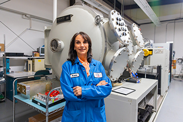 Brenda Rolls in front of the space simulation vacuum chamber