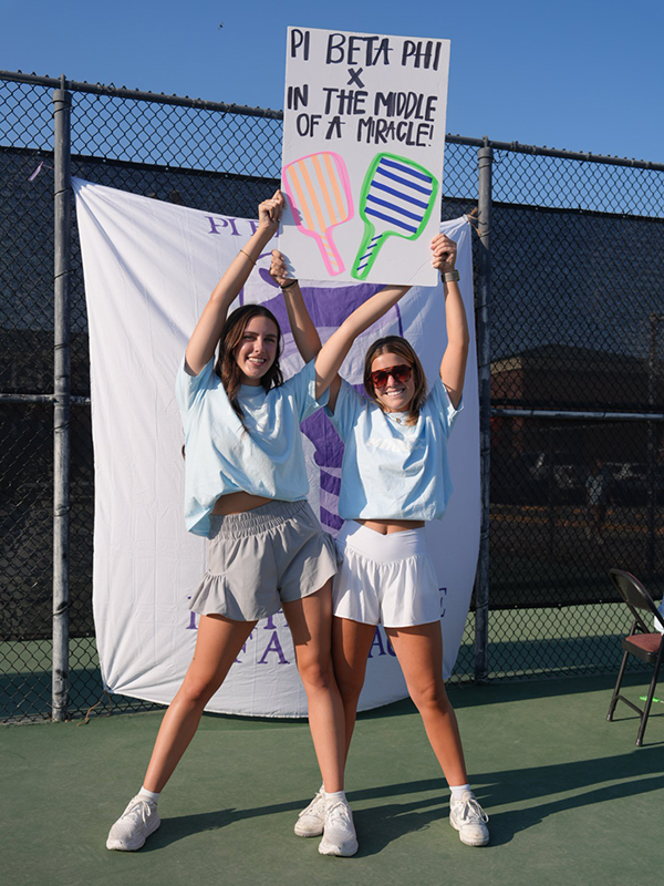 pickleball sorority members hold up a sign