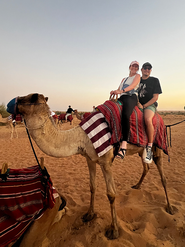 The Buttons ride a camel in the desert.