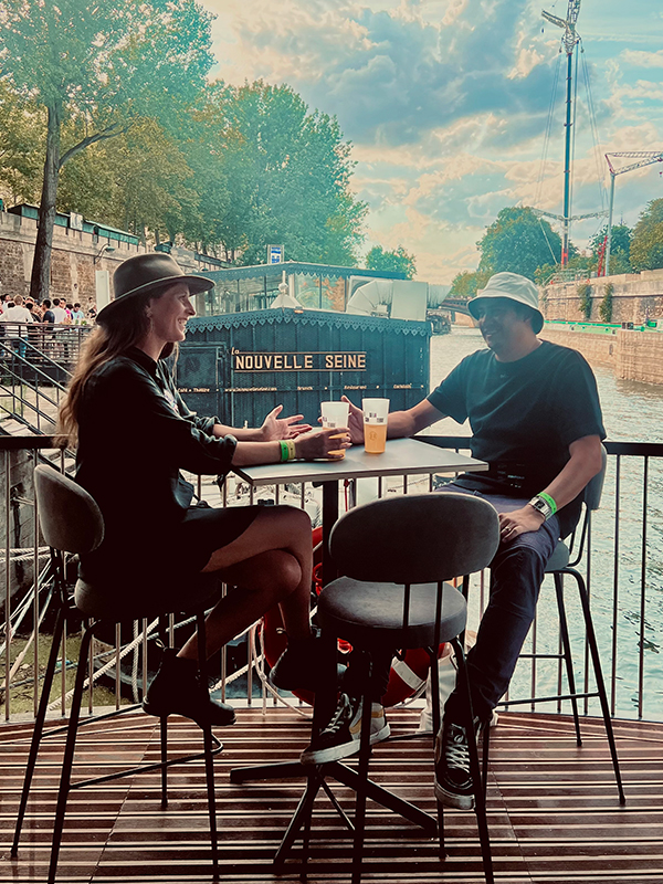 Buttons cafe Quinn and Jon sit at a table at an outdoor cafe.