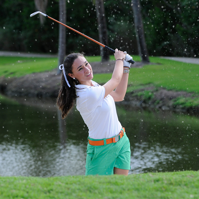 Carina Cuculiza playing a golf shot out of a sand trap during her career at the University of Miami.