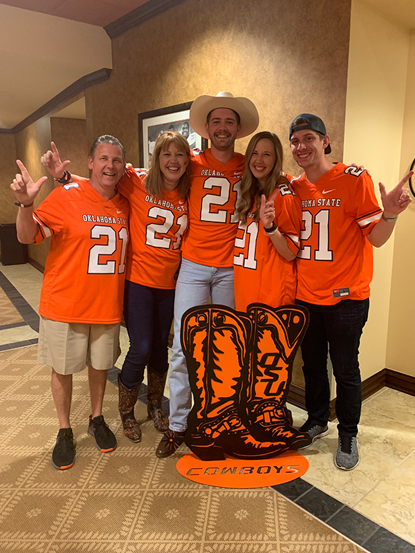 Vickie Carr and her family members wear matching OSU jerseys at a football game.