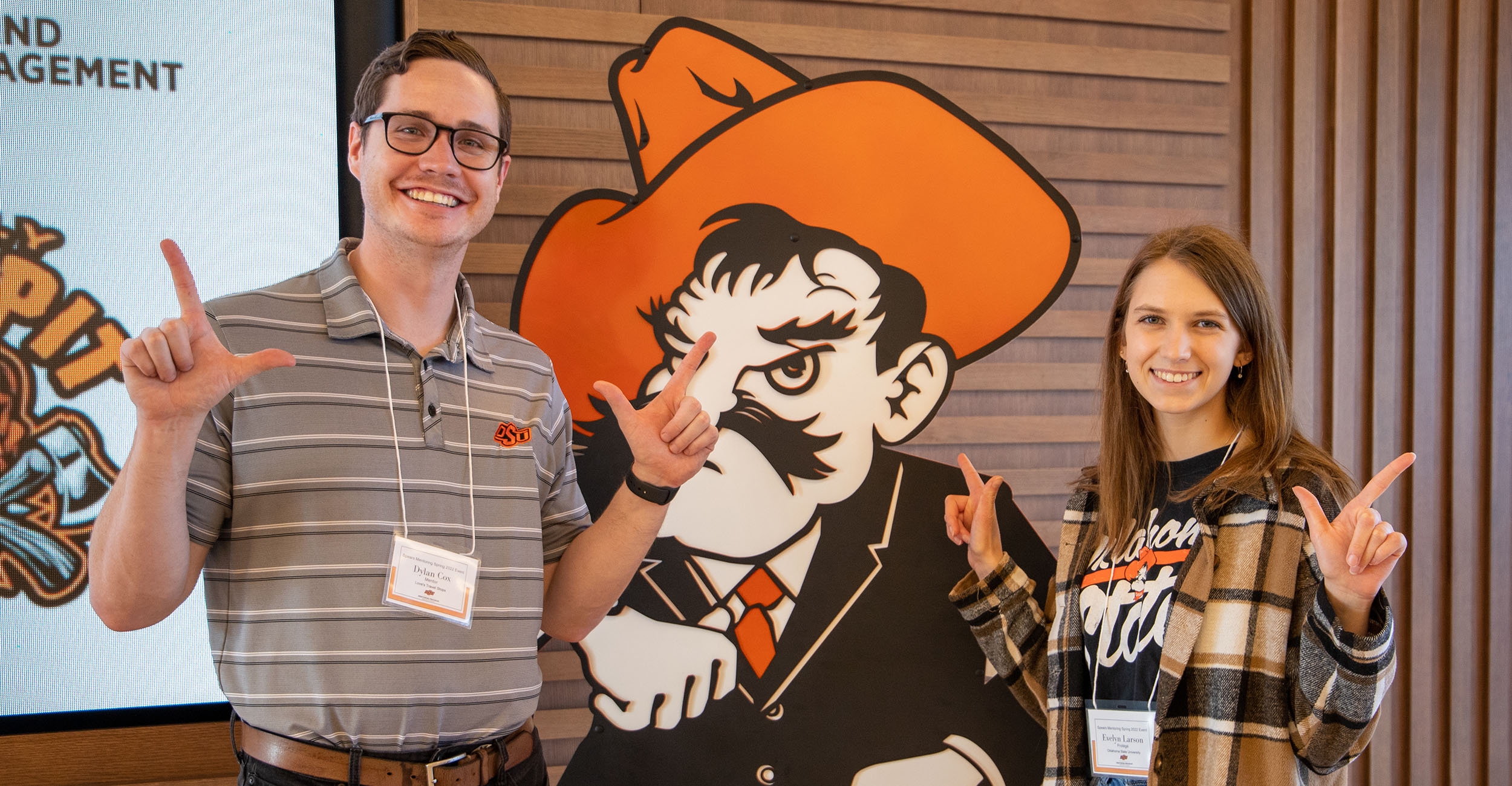 Students pose with a Pistol Pete sign at an Eastin Center event at the Spears School of Business.