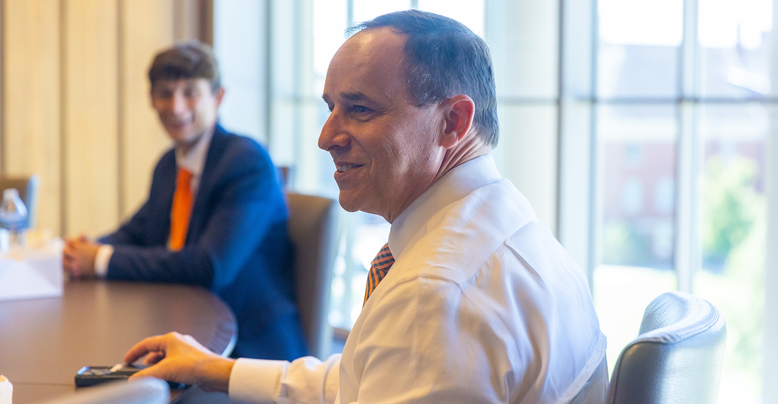 Bryan Edwards smiles while meeting with students in a conference room.