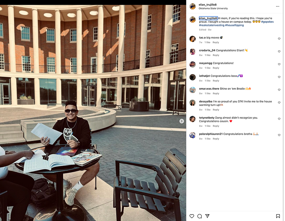 Elian Trujillo signs closing paperwork in Business Building courtyard.