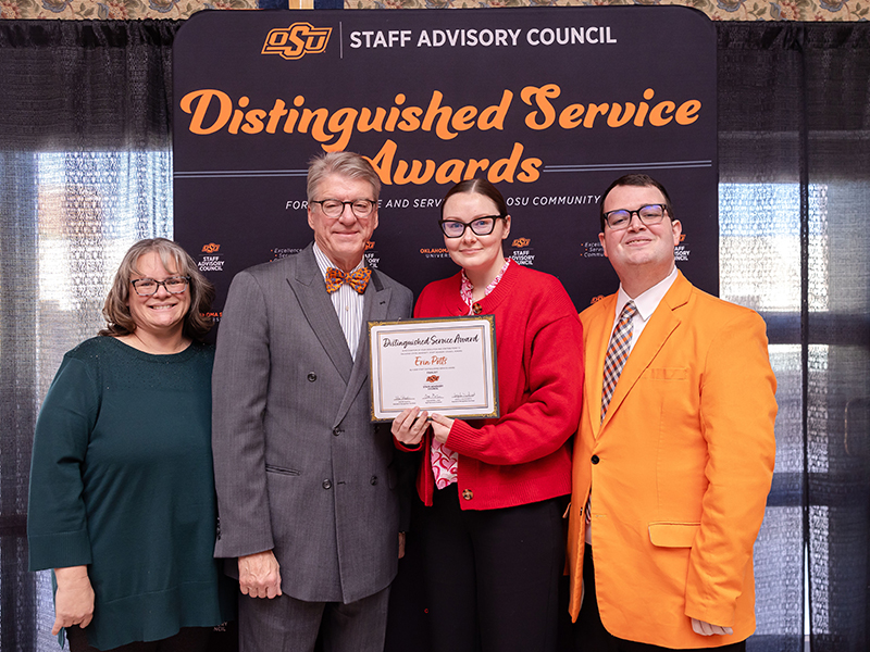 Erin Potts, a woman in a red sweater, holds her certificate.