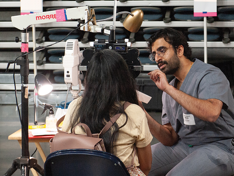 A health care provider examines a patient's eyes.