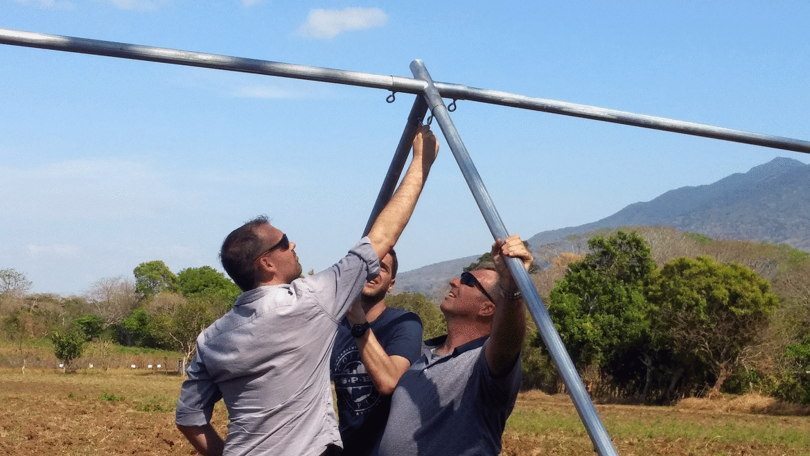 Nathan Richardson (center) helps stabilize a structure for the butterfly farm