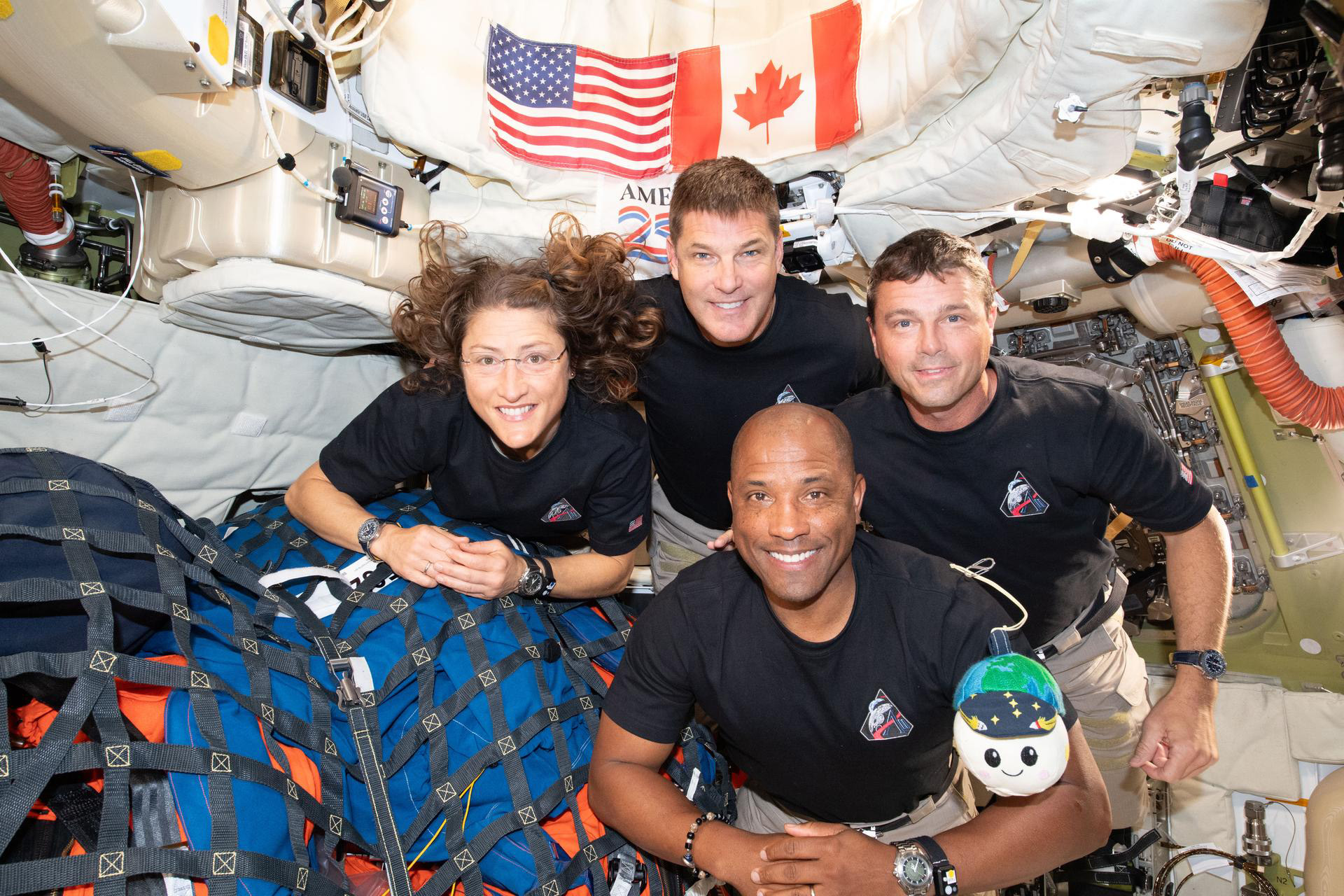 Christina Koch, Victor Glover, Reid Wiseman and Jeremy Hansen in the spacecraft with their zero-gravity indicator plushie, Rise