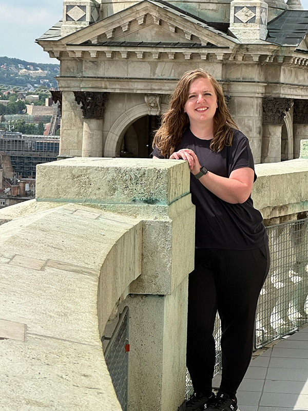 Nicole Neil poses among Central European architecture.