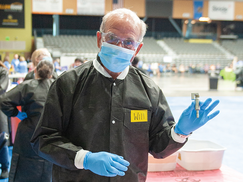 Dr. William Paiva dons a mask, gloves and goggles. 