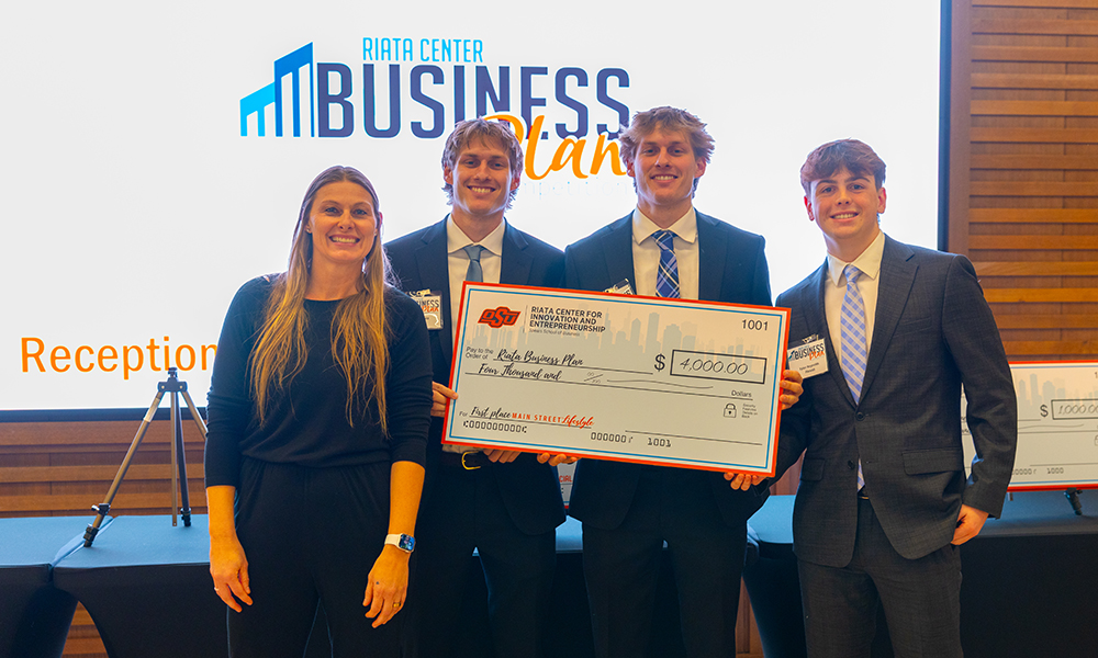 Plenish Pouches Student entrepreneurs hold an oversized check.