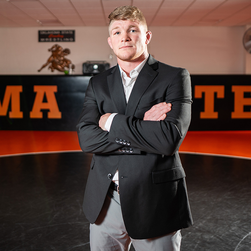 Dustin Plott wears a business suit in the OSU wrestling room.