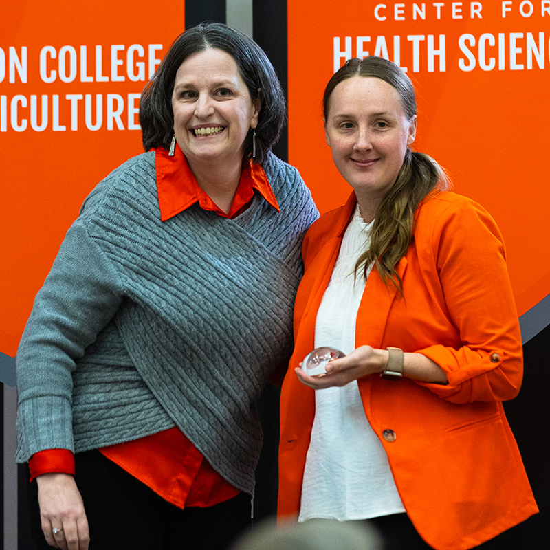 Amber Singleton Amber Singleton, wearing an orange jacket, accepts an award for advising.