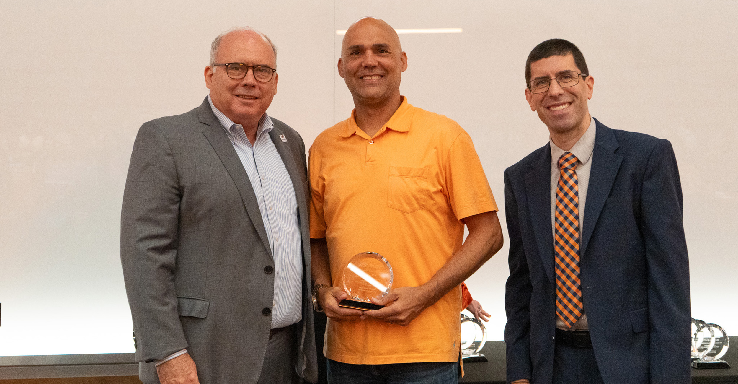 Rick Laux accepts an award from Dean Payne and Chris Francisco.