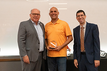 Rick Laux accepts an award from Dean Payne and Chris Francisco.