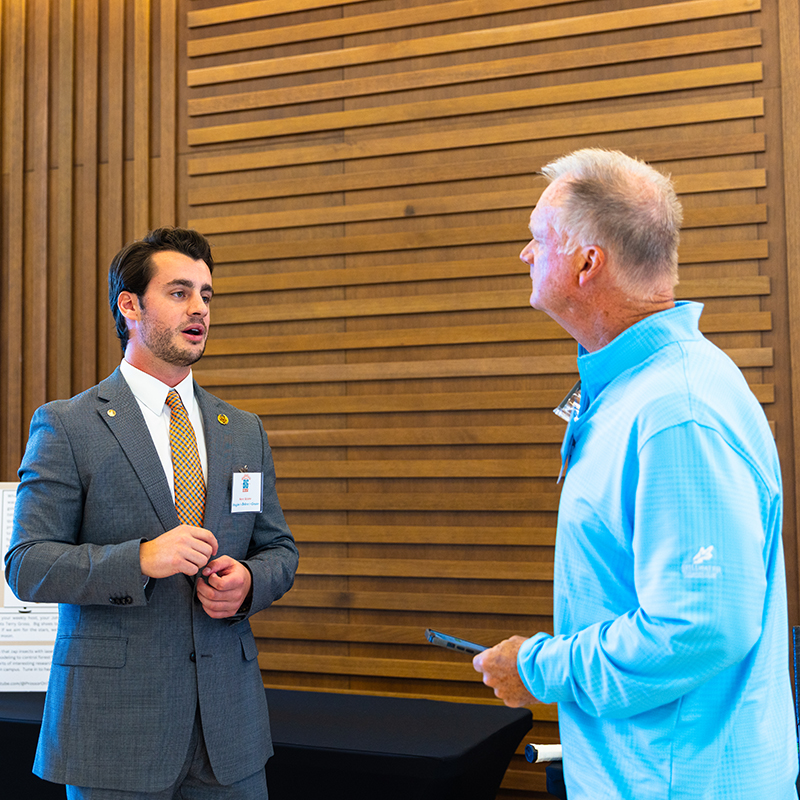 Steve and judge A student talks to a judge at the Student Innovation Expo.