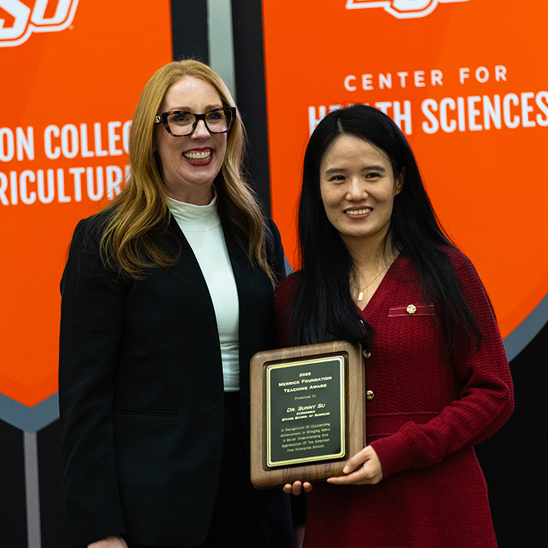 Sunny Su Dr. Sunny Su, a woman in a red dress, holds her new award and stands next to OSU provost Jeanette Mendez.