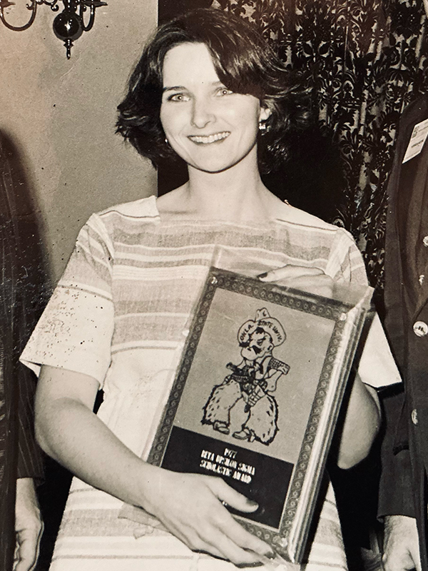 A young Suzanne Wade holds a scholastic award plaque at OSU.