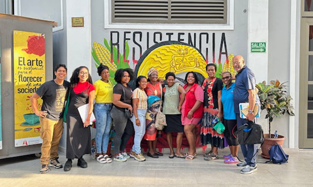 Eleven people line up in front of a mural in Ecuador. Dr. Craig Watters, on the right, stands next to Ecuadorian entrepreneurs.