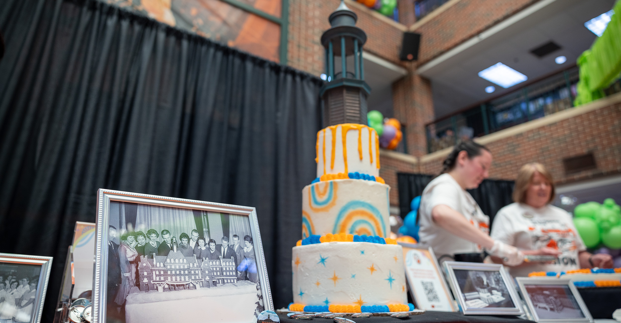 A black and white photograph in a silver frame on a table with pins and a white cake.