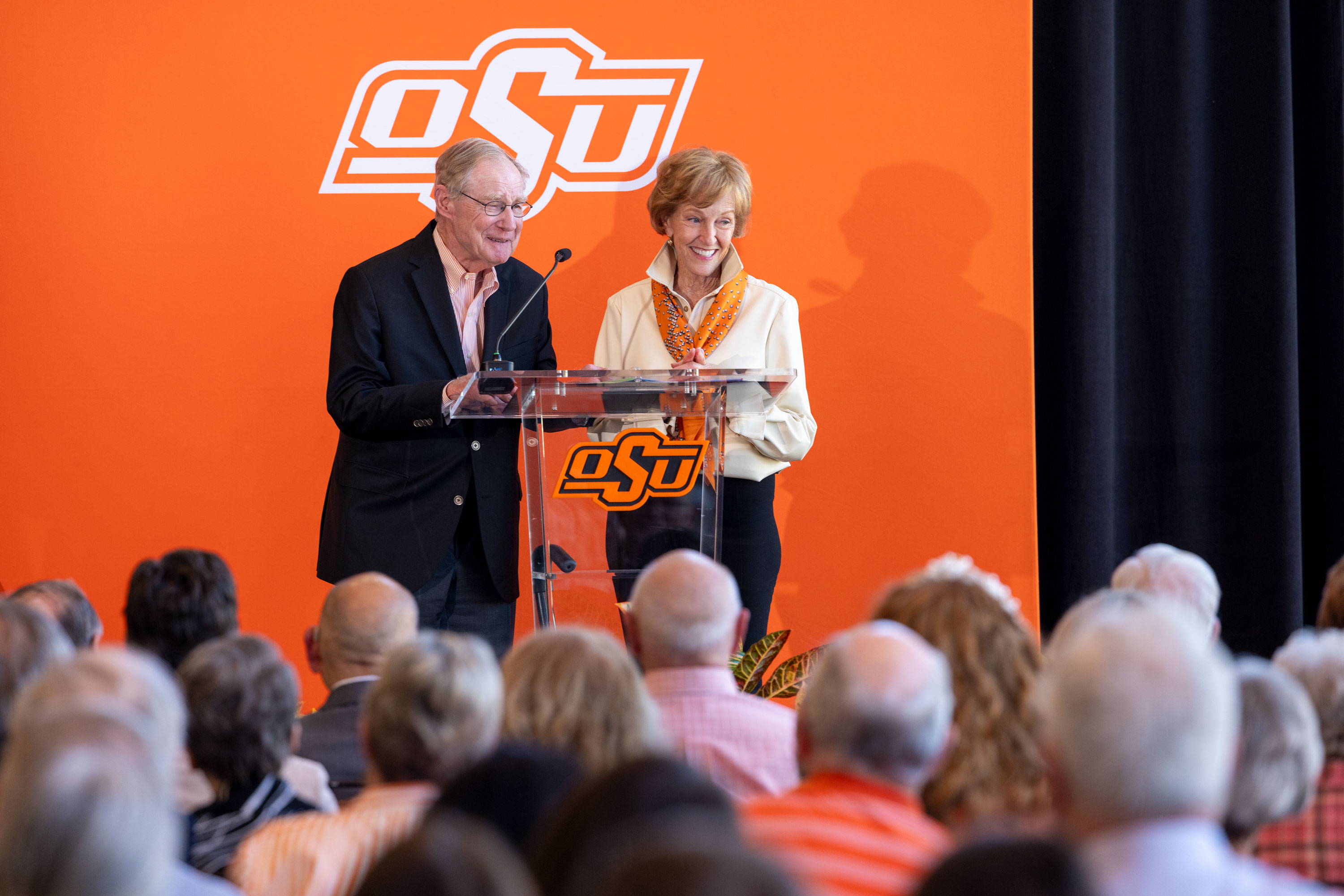 Burns and Ann Hargis give remarks from a podium.