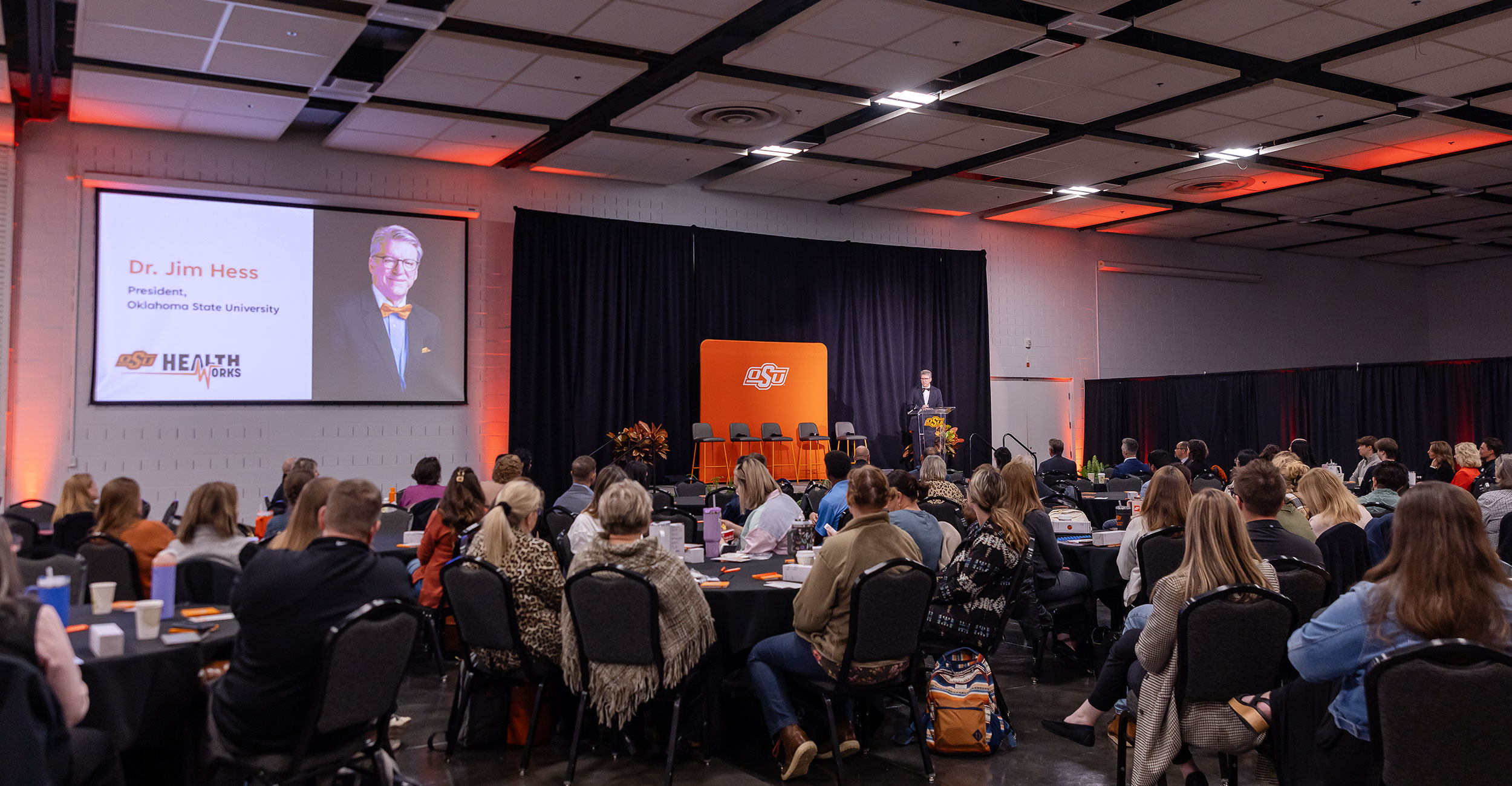 OSU President Jim Hess speaks to the audience from a podium at a heath forum