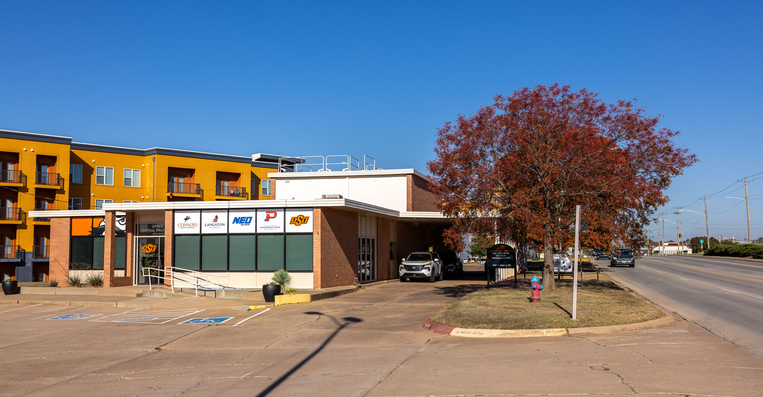a brick office building showing the logos of Oklahoma colleges