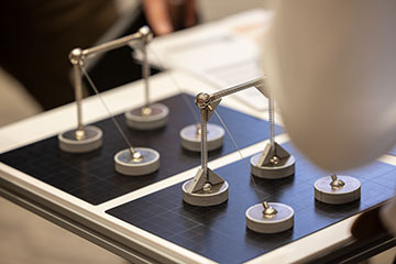 Student architecture research project featuring small-scale structural models made of metal springs and circular bases arranged on a display board.
