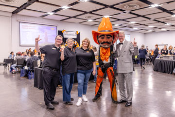 Three members of staff advisory council stand for a group photo next to Pistol Pete and Dr. Jim Hess.