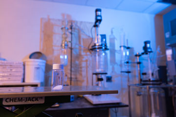 A vial contain samples of PFAS sits on a table in a research laboratory