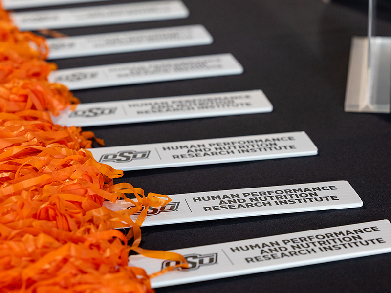 Name badges with orange lanyards for the OSU Human Performance and Nutrition Research Institute are arranged on a table before an event or program gathering.