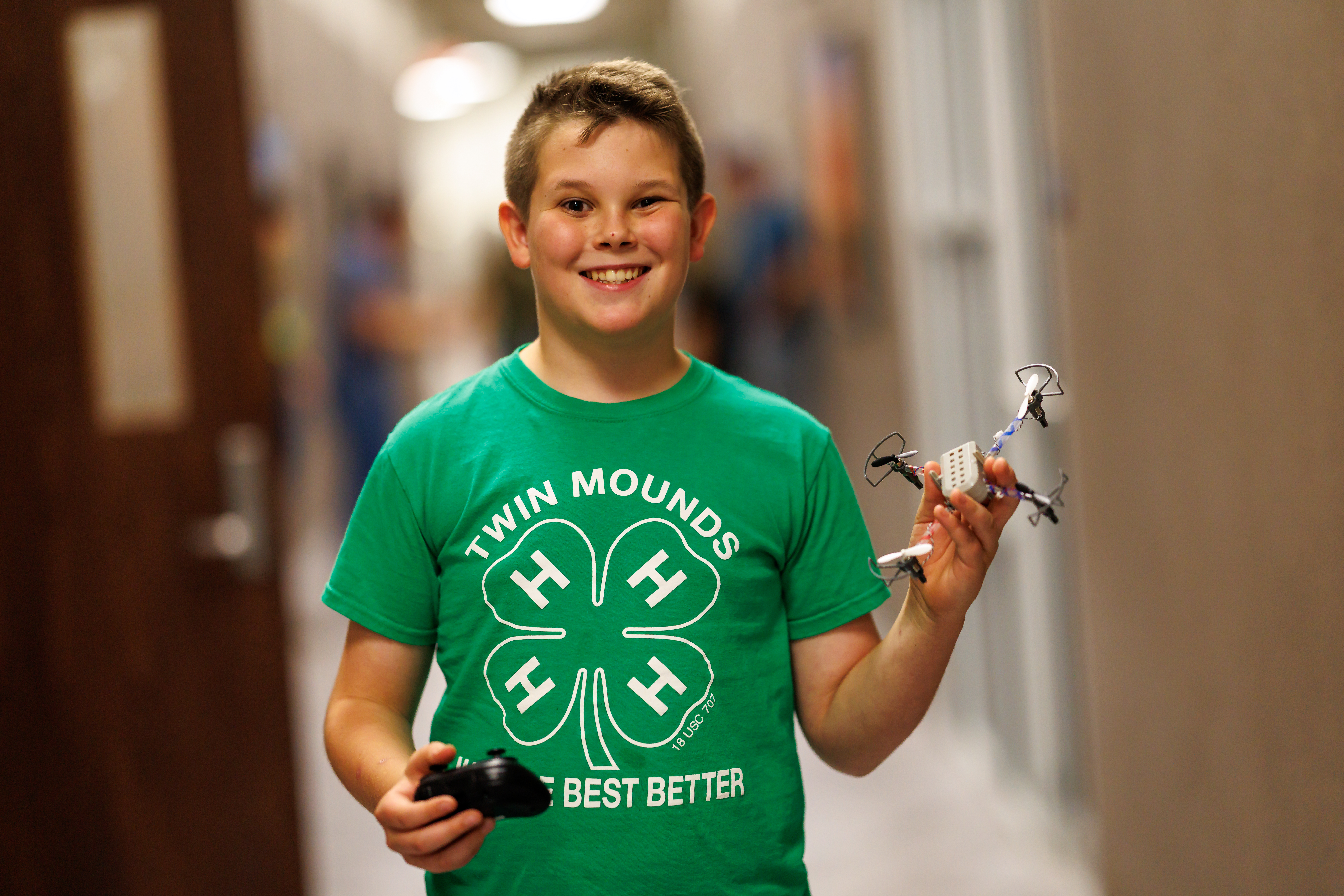 A student holds their drone after building in preparation to fly.